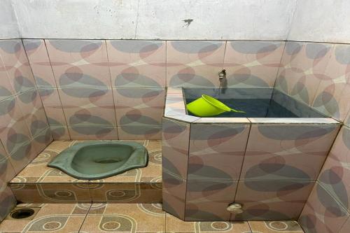 拉旺OYO Life 92982 Kost Berkah Ibu的浴室配有绿色卫生间和水槽。