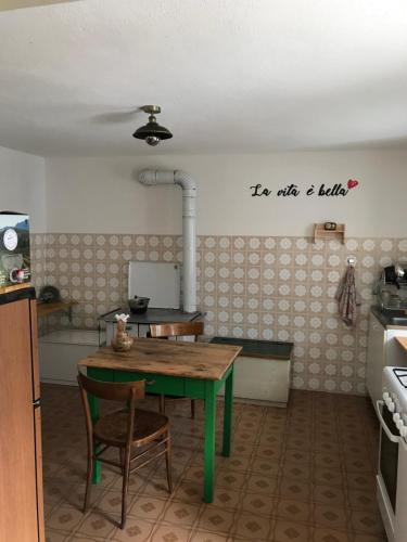 蓬泰巴Ostello Casa Morit的一间带桌子的厨房和一间带炉灶的厨房