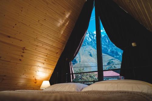 卡兹贝吉Luno Cottage的卧室设有山景大窗户