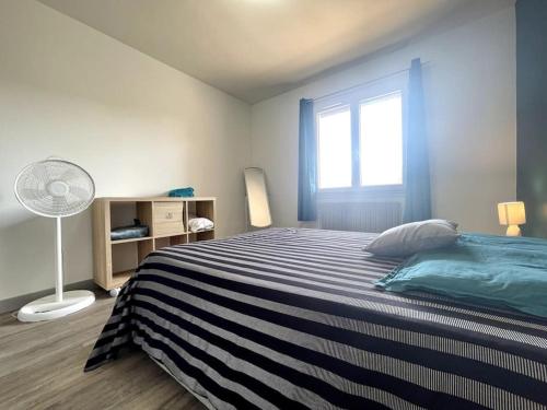 卡尔卡松Maison Bleue ※ Carcassonne的一间卧室设有一张大床和一个窗户。