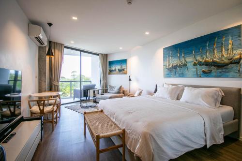 罗勇Escape Condominiums Beachfront Suites - Mae Phim的一间带大床的卧室和一间客厅