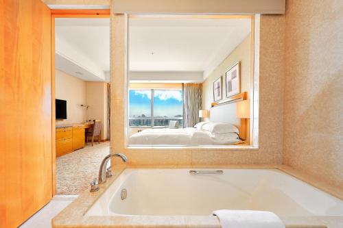 台中市台中裕元花园酒店的酒店客房设有浴缸和卧室。