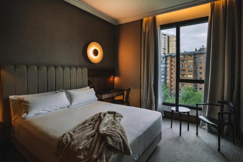 马德里Hotel Pinar Plaza的一间卧室设有一张床和一个大窗户