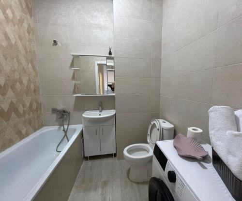 塔尔迪科尔Жк Экспо Авеню的浴室配有卫生间、浴缸和水槽。