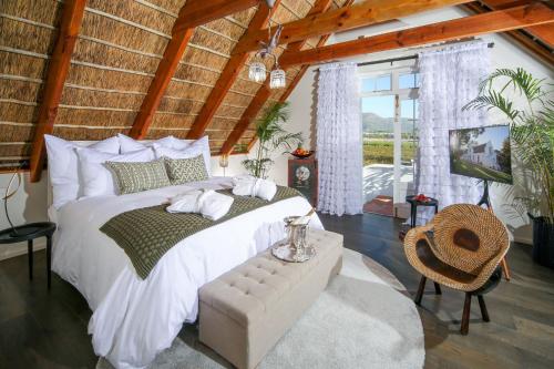 帕尔Adara Palmiet Valley Luxurious Boutique Farm Hotel的卧室配有一张白色大床和电视。
