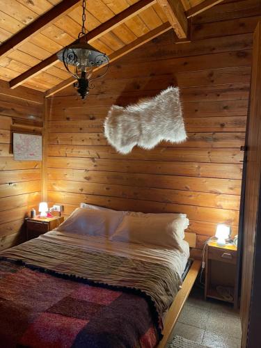 米罗Etna Baite Milo的卧室配有木墙内的一张床