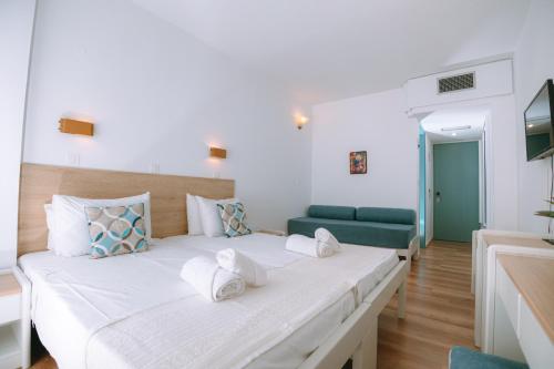 阿基欧斯尼古拉斯Santa Marina Unique Hotel的一间卧室配有一张大床和一张绿色沙发