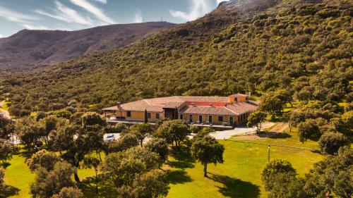 蒙坦切斯Hotel Resort Hípico El Hinojal的山中房屋的空中景观
