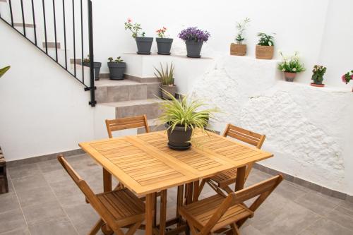 鲁特Casa Rural Los Tablaos的木桌和椅子,在种植了盆栽植物的房间里