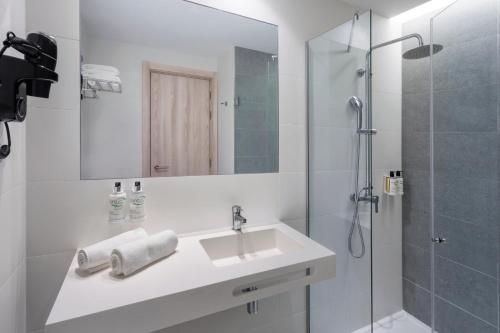 孔迪镇B&B HOTEL Vila do Conde的白色的浴室设有水槽和淋浴。