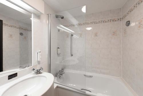 普雷斯科特利物浦乡村酒店的白色的浴室设有浴缸和水槽。