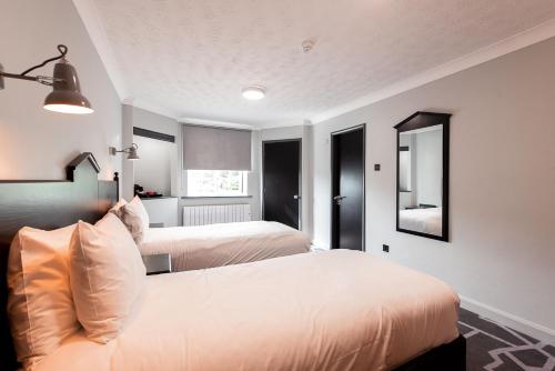 普雷斯科特利物浦乡村酒店的一间卧室配有两张床和镜子