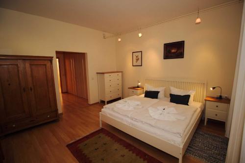 萨斯尼茨Fürstenhof - Ferienwohnung 202的卧室配有白色的床,铺有木地板