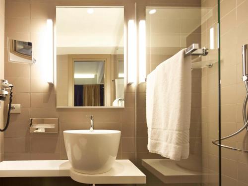 罗马罗马中央斗兽场美居酒店的一间带卫生间、水槽和镜子的浴室