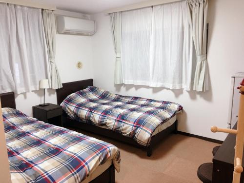 东京Hotel Yuni -Comfortable stay Star-Club iD的一间卧室设有两张床和窗户。