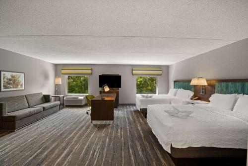 斯帕肯科尔波基普西汉普顿套房酒店的酒店客房,设有两张床和一张沙发