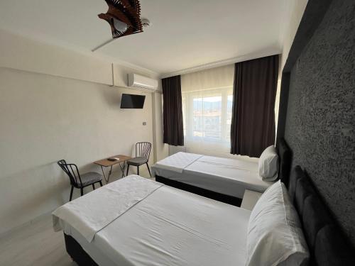 塞尔丘克Nobel Boutique Hotel的酒店客房带两张床和一张桌子以及椅子。