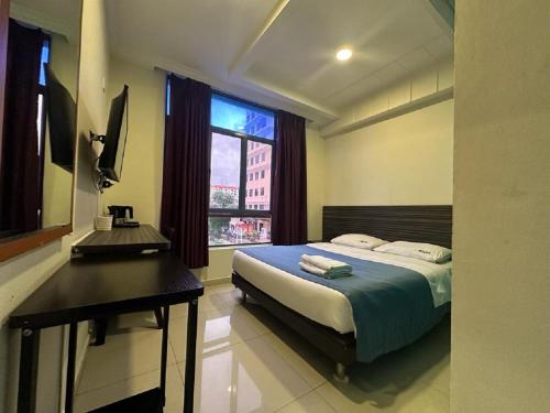 新加坡Darlene Hotel的一间卧室配有一张床、一张书桌和一个窗户。