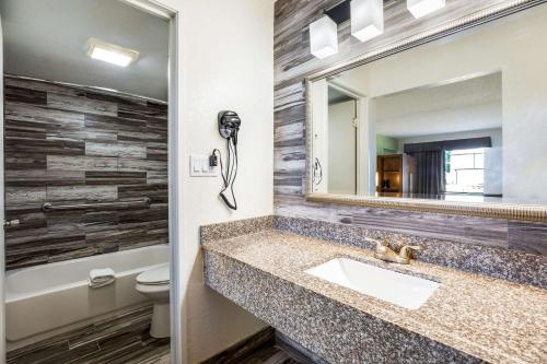 奥兰多Quality Inn & Suites Downtown的一间带水槽和镜子的浴室