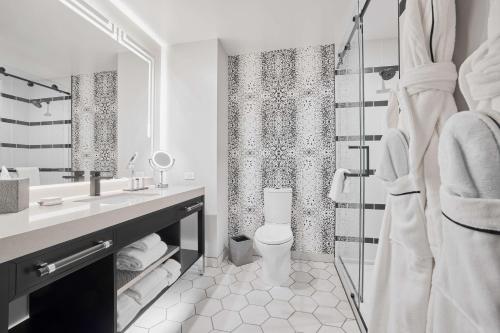 底特律The Godfrey Detroit, Curio Collection By Hilton的白色的浴室设有卫生间和淋浴。