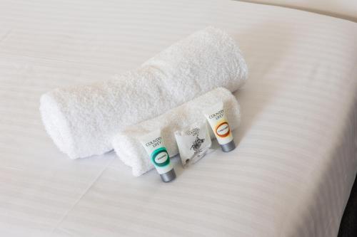 古尔本Exchange Hotel Goulburn的床上的两条毛巾和两条牙刷