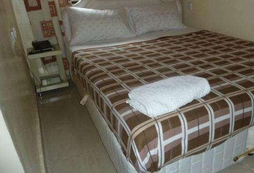 阿沙巴Room in Lodge - Vision Serviced Apartments的一张配有棕色和白色床单及枕头的床