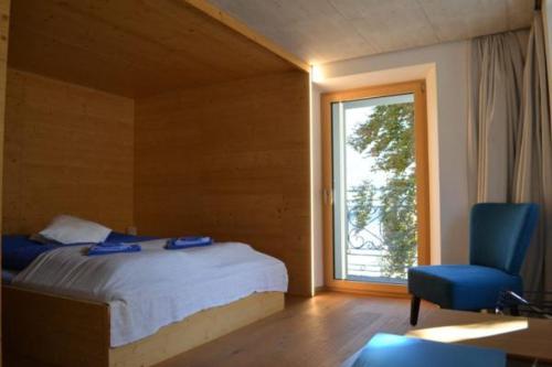 DalpeHotel des Alpes Dalpe的卧室配有床、椅子和窗户。