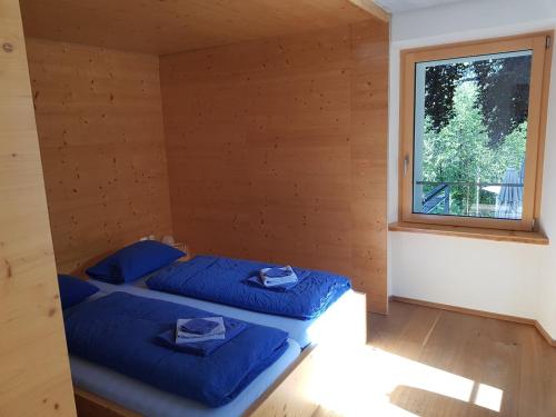 DalpeHotel des Alpes Dalpe的带窗户的客房内的两张床
