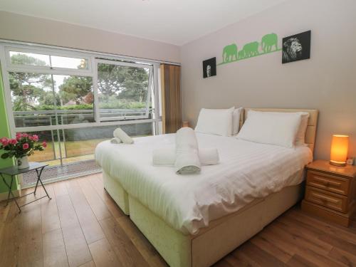 浦耳Flat 5 Fairwinds的卧室设有一张白色大床和一扇窗户。