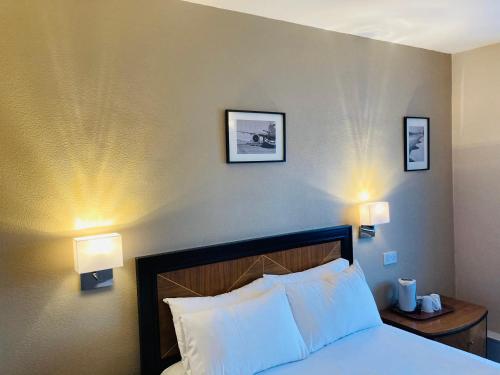 泰恩河畔纽卡斯尔大不列颠纽卡尔斯机场酒店的卧室配有一张带两盏灯的墙壁床。