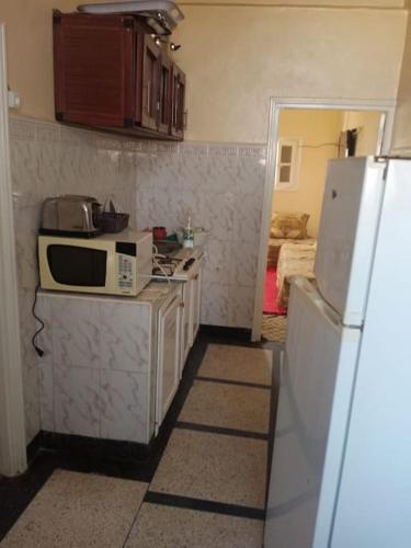 贝尼迈拉勒appartement au centre ville的厨房配有微波炉和冰箱。