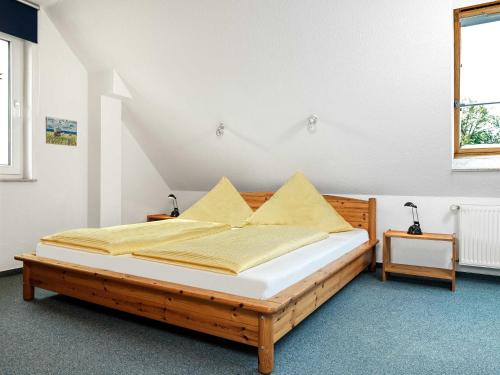 KirchdorfHafenkieker的一间卧室配有一张带黄色枕头的木床
