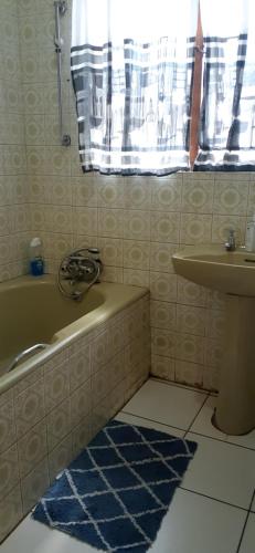 恩潘盖尼Kwesethu Guesthouse的带浴缸和盥洗盆的浴室