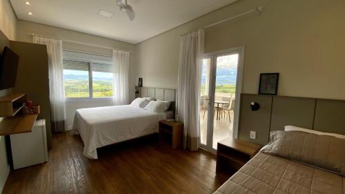 圣若昂-巴蒂斯塔-杜格罗里亚Pousada Vila Craton Canastra的一间卧室设有一张床和一个美景窗户。