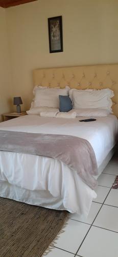恩潘盖尼Kwesethu Guesthouse的卧室配有一张带白色床单和枕头的大床。