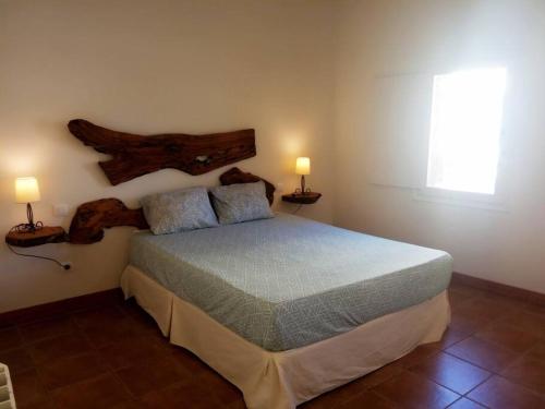 Torre del CompteEl Olivo的卧室配有一张床,墙上挂着两盏灯