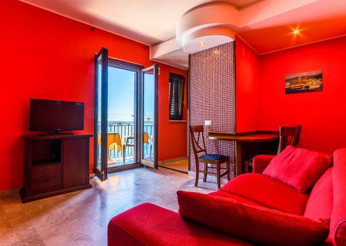 切法卢MiraMare Residence Cefalú的客厅设有红色的墙壁和红色的沙发