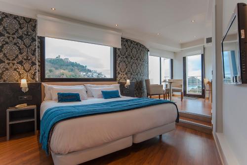圣塞瓦斯蒂安斯考特而科迪纳酒店的一间卧室设有一张大床和大窗户