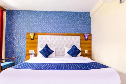 马拉里FabHotel Negis Shivalay的一间卧室配有一张带蓝色墙壁的大床