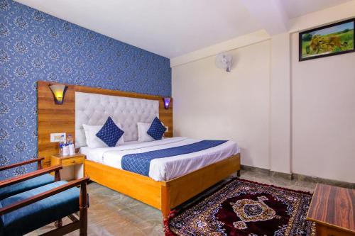 马拉里FabHotel Negis Shivalay的一间卧室配有一张蓝色墙壁的床