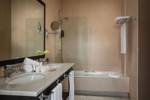 莫哈卡尔ALEGRIA Palacio Mojacar - Adults Only的浴室配有两个盥洗盆和浴缸。
