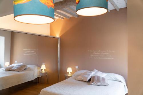 坎丕里亚麦利蒂玛Losanna Suites的一间卧室配有两张床、镜子和灯