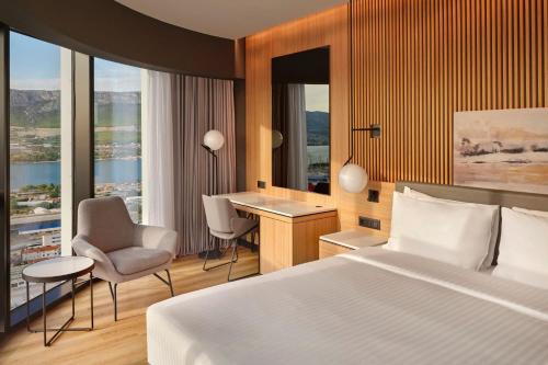 斯普利特AC Hotel by Marriott Split的酒店客房,配有一张床、一张桌子和椅子