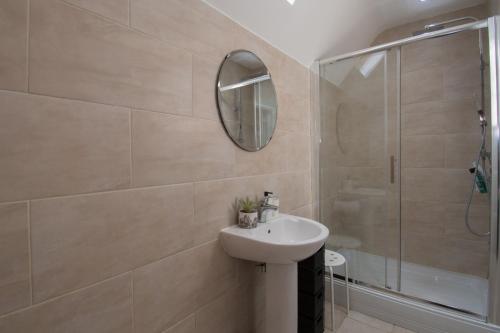 卢顿Elegant and spacious private room with ensuite的一间带水槽、淋浴和镜子的浴室