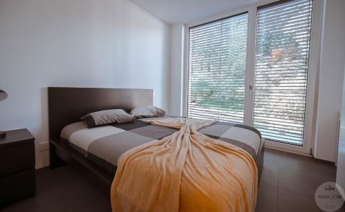 WakeUp Lux-City的一张位于带大窗户的房间内的床铺