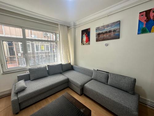 伊斯坦布尔1+1 Flat in Fatih Aksaray的带沙发和窗户的客厅