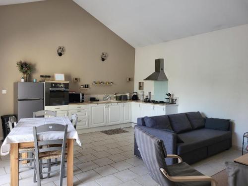 阿维尼翁Maison au calme Avignon - Clim - Wi-Fi的厨房以及带桌子和沙发的客厅。