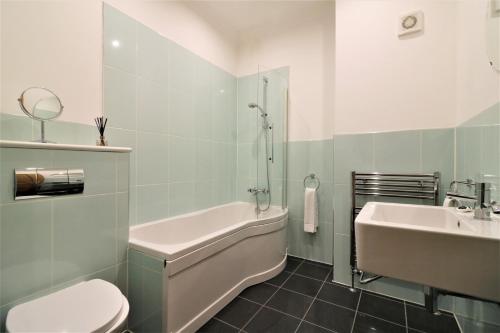 CambuslangGreenlees Clubhouse 3 Bed的一间带水槽、浴缸和卫生间的浴室