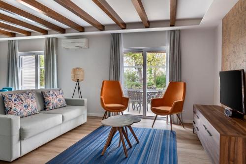 金塔湖Vilar do Golf的客厅配有沙发、椅子和电视