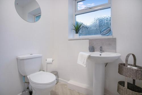 CrookSweet Home with Backyard in Howden-le-Wear for 3的一间带卫生间、水槽和窗户的浴室